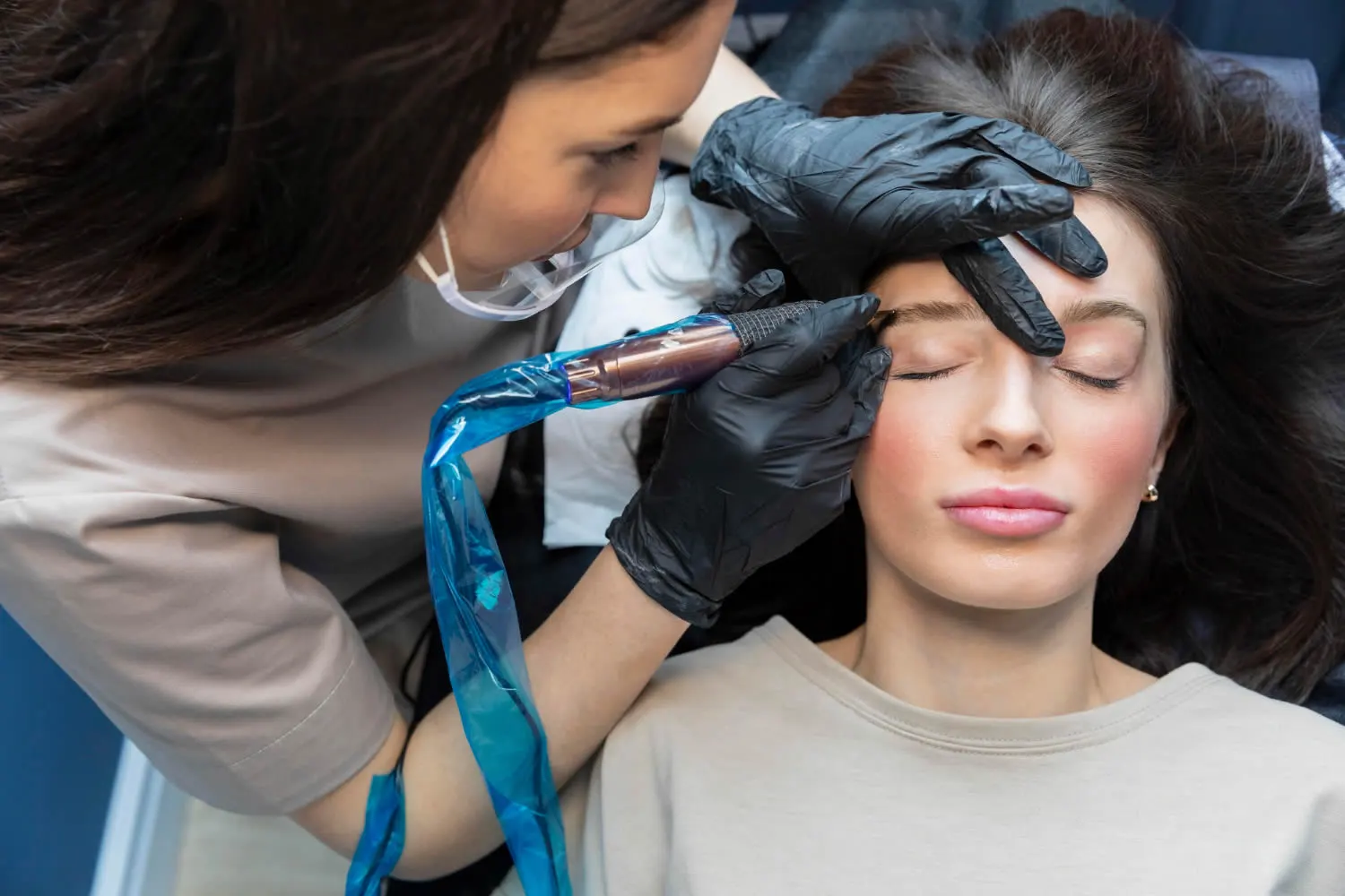 medical dermatology woman beautician-doing-eyebrow-treatment-permanent-makeup
