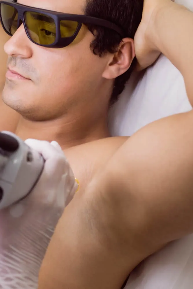 happy mature woman dermatologist-performing-laser-hair-removal-male-patient